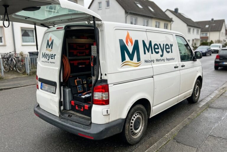 Gebrandetes Servicefahrzeug von Meyerheizung vor einem Wohngebäude